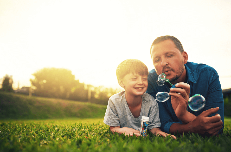 man with son blowing bubbles